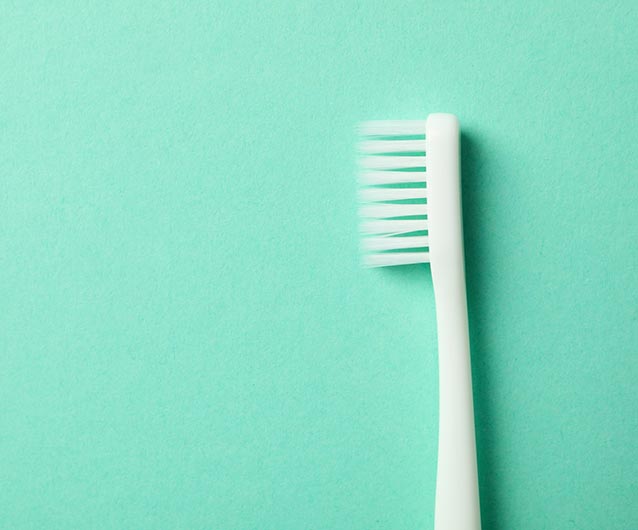 Toothbrush on mint background, space for text Best Dentist in Ottawa Ontario